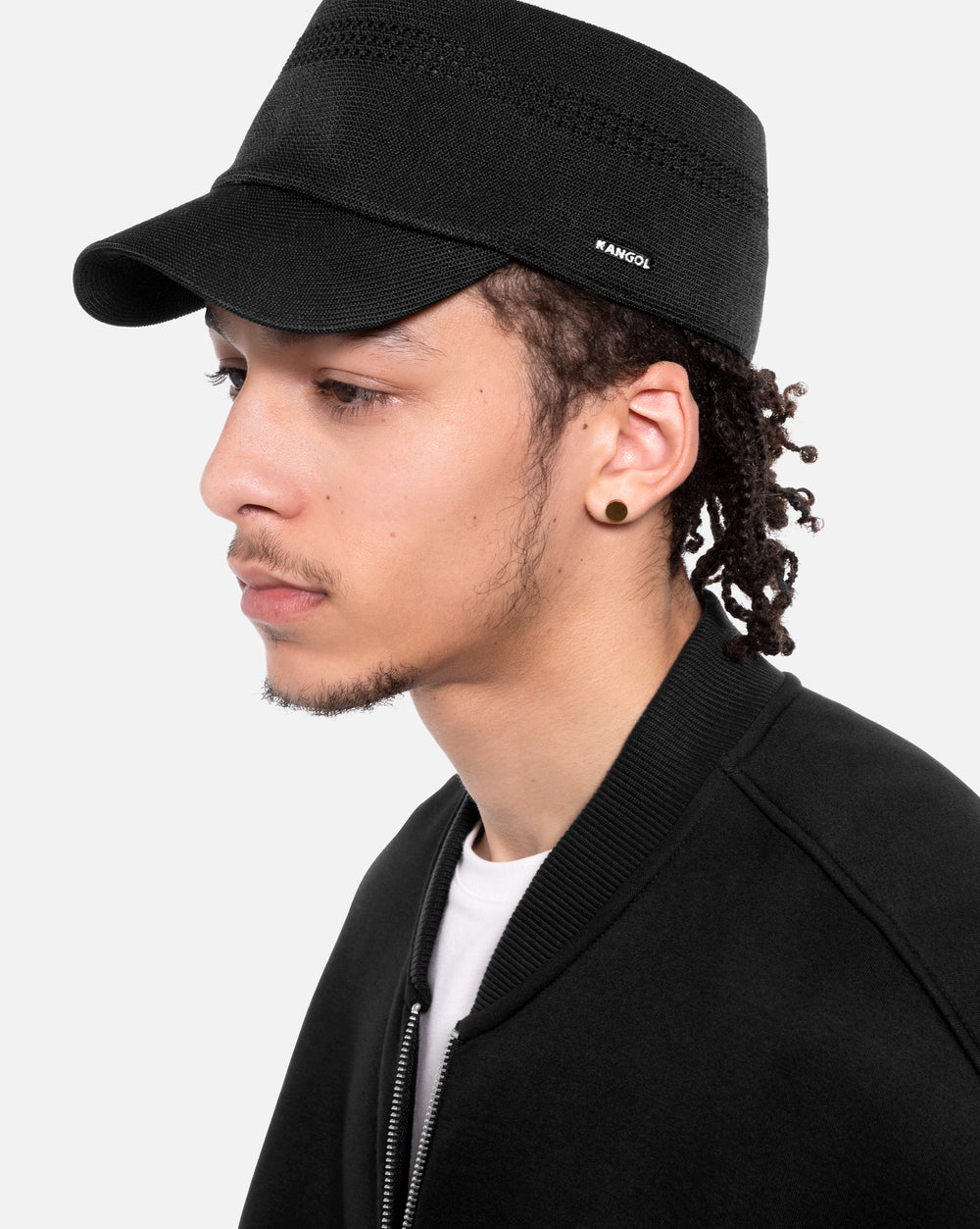 Person wearing a black cap with 'KANGOL' branding on a white background