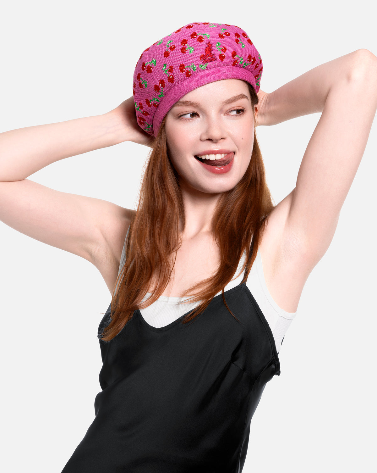 Woman wearing a pink beret with cherry pattern on a white background
