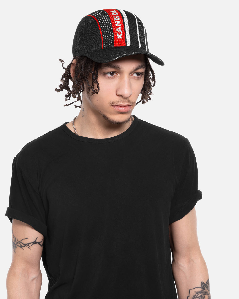Person wearing a black baseball cap with red and white accents on a white background