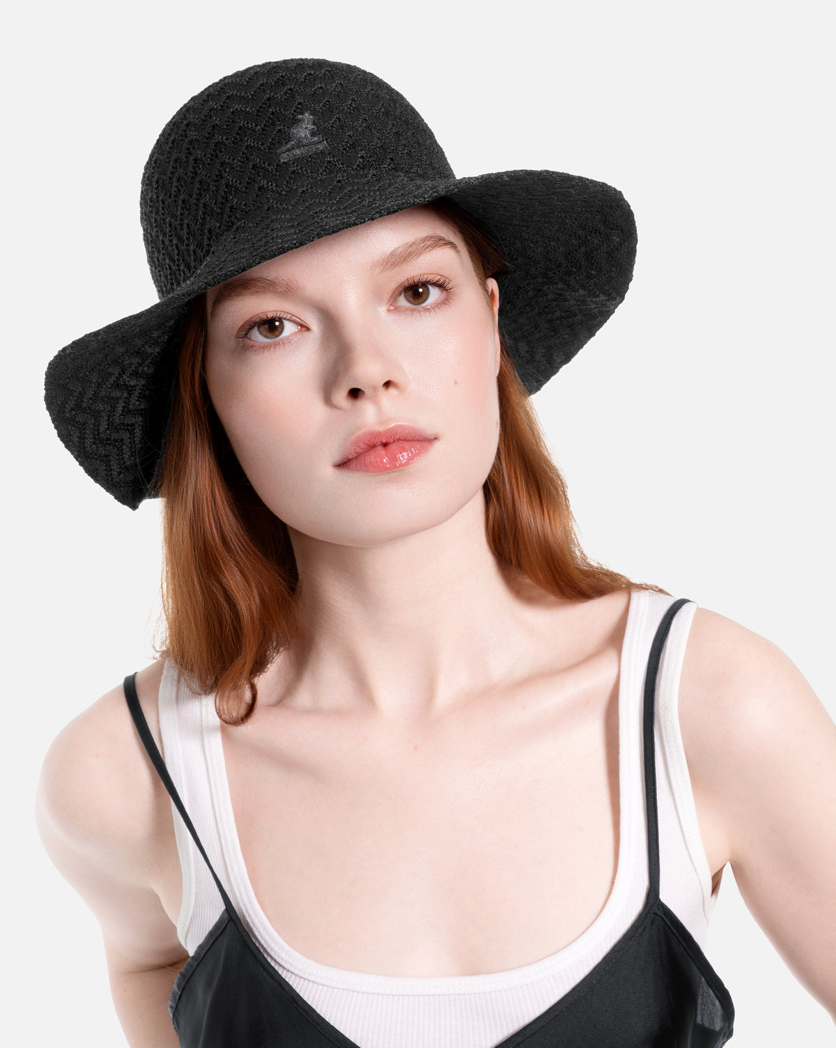 Woman wearing a black knit sun hat on a white background
