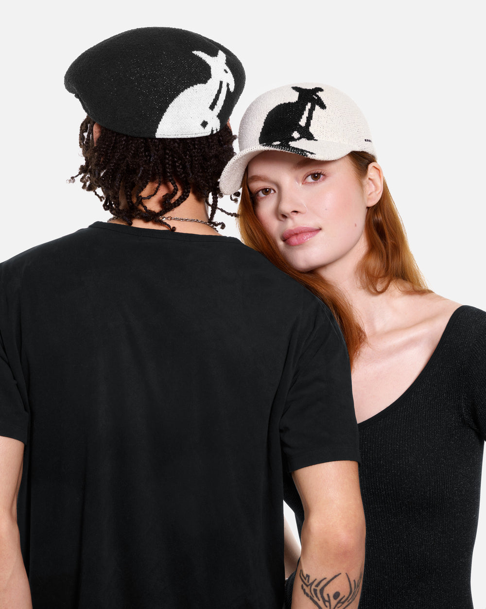Two people wearing black t-shirts with a kangaroo logo on a plain background