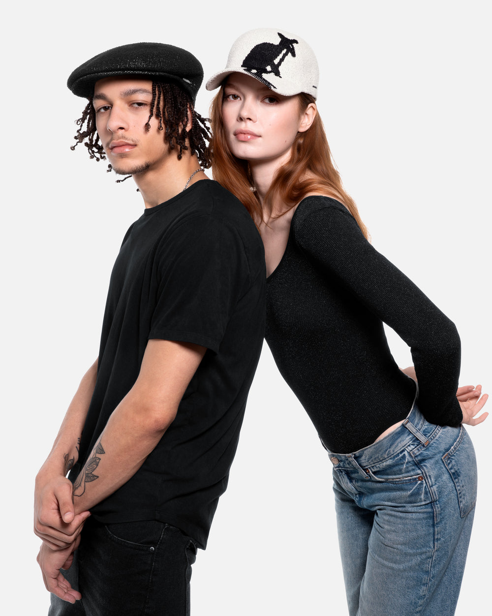 Two people wearing black clothing and hats with kangaroo logo against a white background