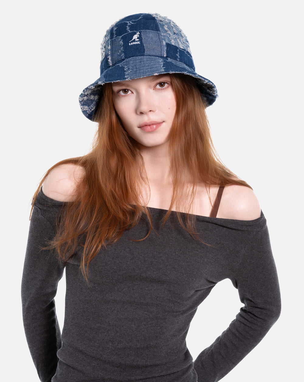 Woman wearing a blue denim bucket hat on a white background