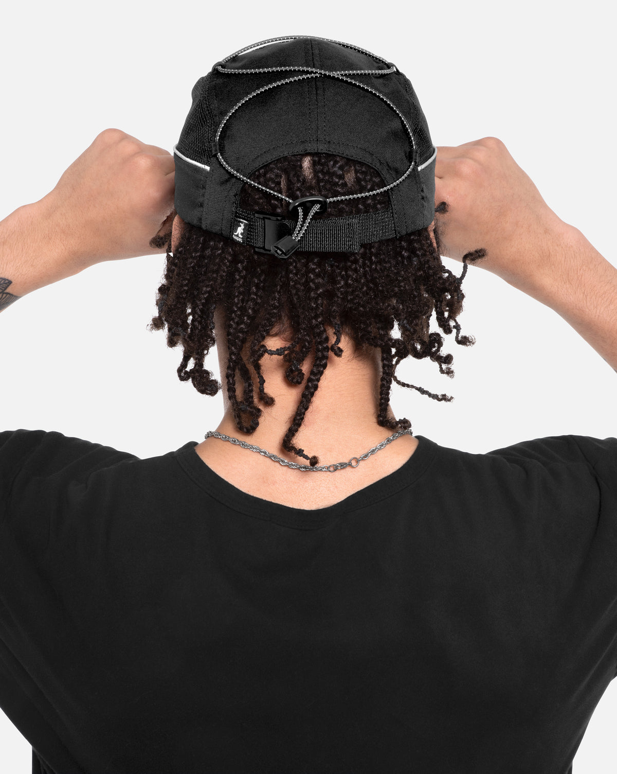 Person wearing a black cap with a lace front wig on a white background