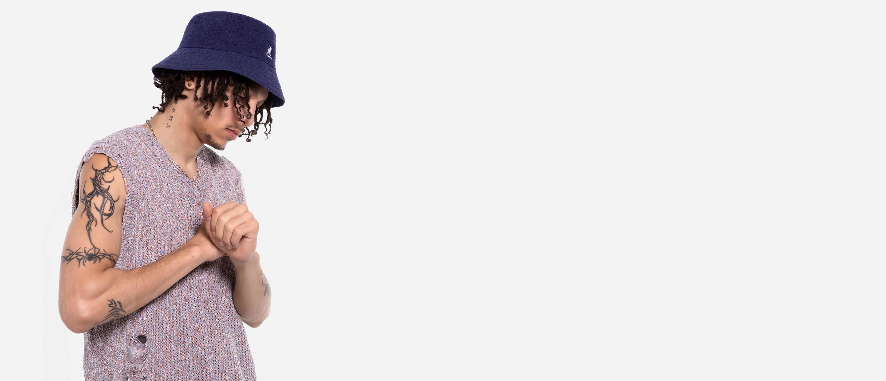 Person wearing a blue bucket hat and patterned shirt on a white background