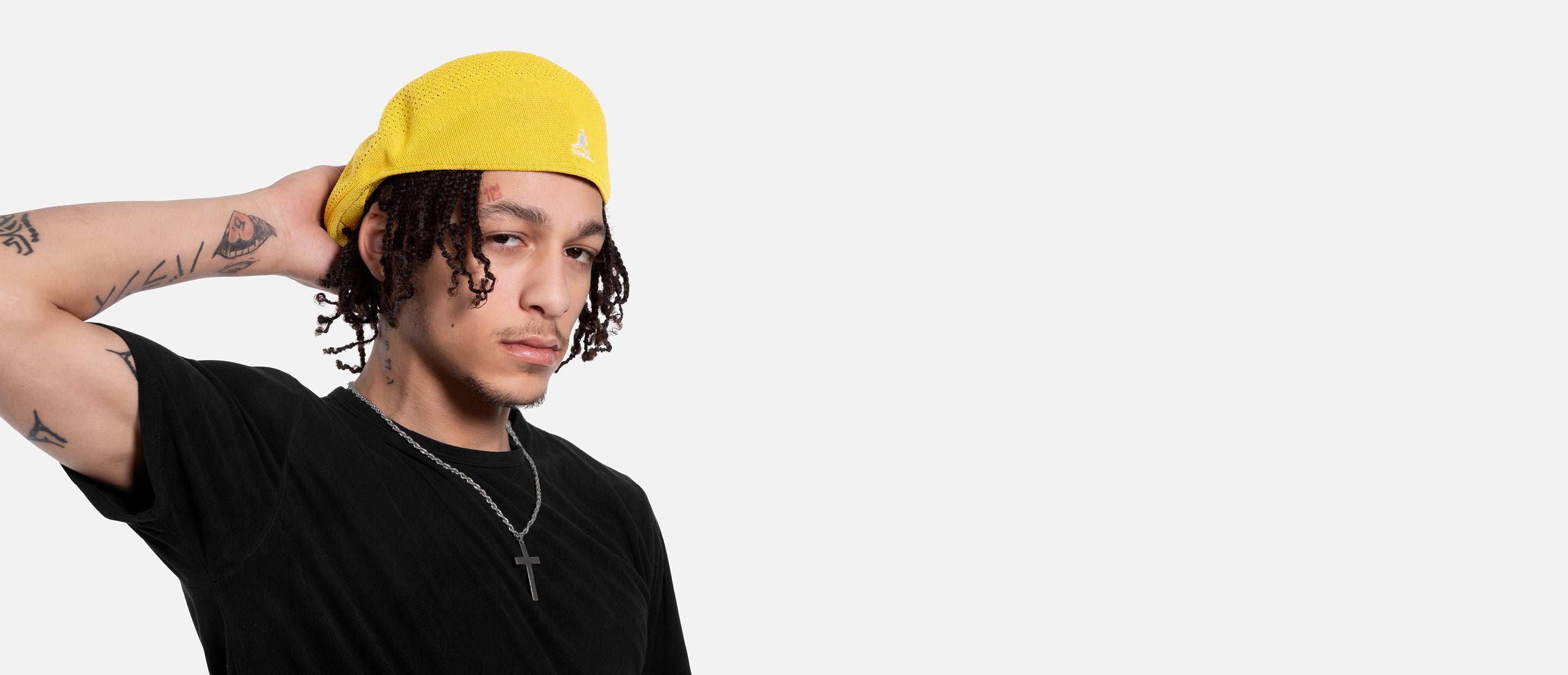 Person wearing a yellow cap and black shirt on a white background